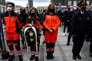 Ratownicy medyczni z wieńcami podczas pogrzebu policjanta.