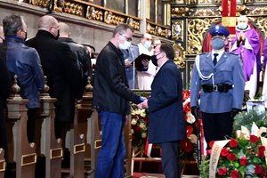 Minister Mariusz Kamiński przekazuje rodzinie medal nadany pośmiertnie policjantowi.