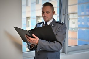 Widoczni umundurowani policjanci podczas składania kwiatów przed Tablicą Pamięci w KWP w Katowicach