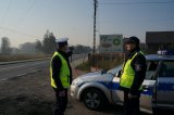 Awatar policjanci stojąc obok radiowozu z urządzeniem do pomiaru prędkości pojazdów sprawdzają czy kierowcy poruszają się zgodnie z przepisami