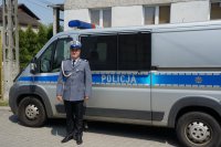 awansowany policjant z drogówki na tle radiowozu