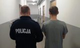 Zdjęcie kolorowe. Na zdjęciu znajduje się policjant stojący tyłem oraz sprawca kradzieży z włamaniem