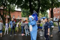 Maskotka śląskiej Policji ,,Sznupek&quot; w otoczeniu dzieci biorących udział w festynie