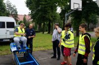 Dzieci testują symulator zderzeń pod czujnym okiem policjanta