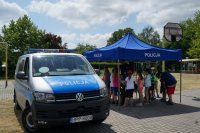 Raciborscy policjanci podczas pikniku wakacyjnego wśród dzieci pokazują sprzęt policyjny