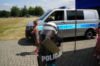 Raciborscy policjanci podczas pikniku wakacyjnego wśród dzieci pokazują sprzęt policyjny