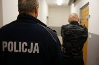 zdjęcie kolorowe przedstawiające policjanta z zatrzymanym 30-latkiem