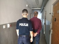 zdjęcie kolorowe przedstawiające policjanta z osobą zatrzymaną za rozbój