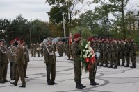 Delegacja wojska składa wiązankę pod tablicą zabitych saperów