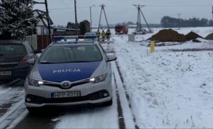 Policyjny radiowóz na tle wykopanego niewybuchu