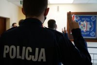 Policjanci z uniesionymi prawymi dłońmi mówią policyjną przysięgę