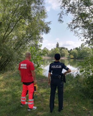 Dzielnicowa i ratowniku Wodnego Ochotniczego Pogotowia Ratunkowego kontrolują żwirownię pod kątem bezpieczeństwa nad wodą