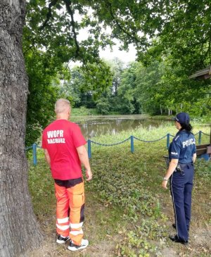 Dzielnicowa i ratowniku Wodnego Ochotniczego Pogotowia Ratunkowego kontrolują żwirownię pod kątem bezpieczeństwa nad wodą