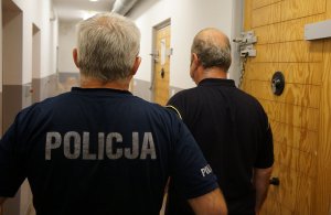 Policjant stojący ze złodziejem, który ukradł kobiecie torebkę