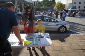 Mama z dzieckiem stoją przy stoisku policyjnym