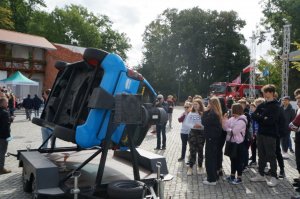 Uczniowie stoją obok symulatora dachowania, a inni są w środku