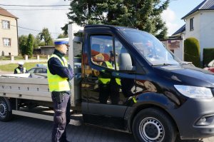 Policjant z drogówki stoi obok samochodu