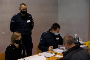 Raciborscy policjanci przy stoliku wspólnie z obserwatorem ćwiczeń z Komendy Wojewódzkiej Policji w Katowicach