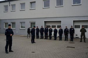 Zastępca Komendanta Policji w Raciborzu wita rezerwistów stojących w dwuszeregu, a zboku stoją raciborscy policjanci