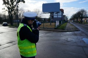 Policjant drogówki z radarem mierzy prędkość