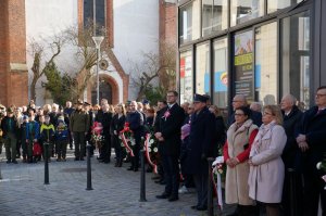 Przedstawiciele służb mundurowych i mieszkańcy pod pomnikiem abp. Józefa Gawliny na raciborskim Rynku