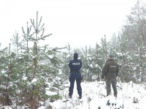 Policjantka i strażnik leśny na tle lasu