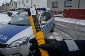 Policjant z drogówki z urządzeniem do mierzenia alkoholu w organizmie