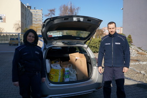 Komendant i policjantka na tle radiowozu z darami dla mieszkanców Ukrainy