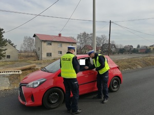 Policjanci z drogówki kontrolują samochód