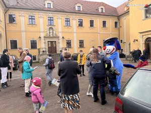 Plac Opactwa w Rudach, a na nim dzieci z Ukrainy wraz z rodzicami, maskotka policyjna Sznupek i raciborscy Policjanci