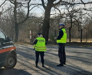 Policjant i sokiści stoją w okolicy przejazdu kolejowego w Szymocicach i reagują na wykroczenia