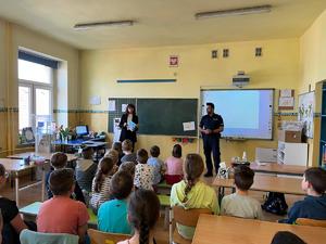 Klasa szkolna dzieci i nauczycielka podczas wykładu o bezpieczeństwie podczas prac na wsi