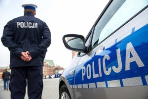 Policjant na tle radiowozu