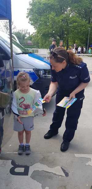 Policjantaka daje dziecku kolorowankę