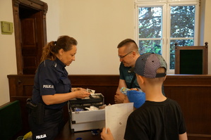 Policjantka pokazauje zawartość walizki profilaktycznej