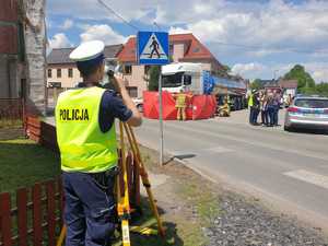 Policjant raciborskiej drogówki na miejscu wypadku mierzy tachimetrem