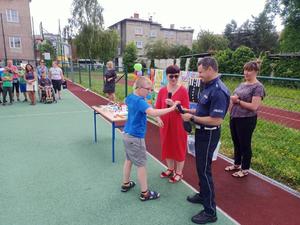 Policjant na rozdaniu nagród dla uczestników konkursu plastycznego w Zespole Szkół Specjalnych w Raciborzu