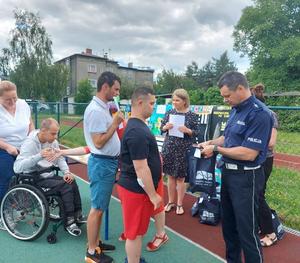 Policjant na rozdaniu nagród dla uczestników konkursu plastycznego w Zespole Szkół Specjalnych w Raciborzu