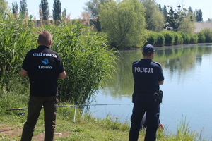 Policjant i przedstawieciel straży rybackiej podczas wspólnego patrolu