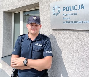 Policjant na tle komisariatu