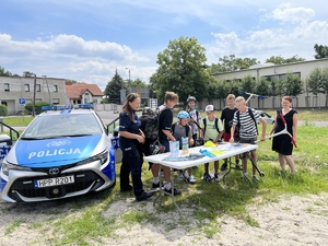 Dzieci i policjanci na tle radiowozu