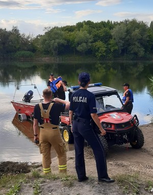 Policjantka i strażacy nad wodą