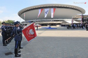 Poczty sztandarowe Policji na tle spodka w Katowicach