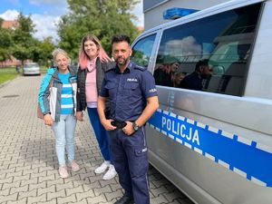 Pamiątkowe zdjęcie na tle radiowozu policjanta i Emilii z mamą