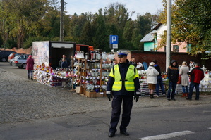 Policjant z drogówki na tle cmentarza