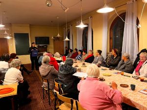 Policjant wśród mieszkańców siedzi w czasie debaty społecznej