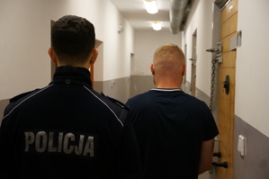 Policjant stoi obok kierowcy, który kierował pijany samochodem i dodatkowo obiecywał łapówkę