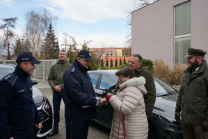 Policjant otrzymuje kluczyki do nowego radiowozu od Anny Iskały wójtowej Nedzy