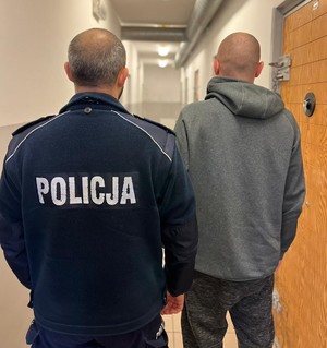 Zatrzymany mężczyzna związany z posiadaniem narkotyków stoi z policjantem