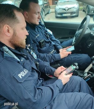 Policjanci w radiowozie z e-notatnikami